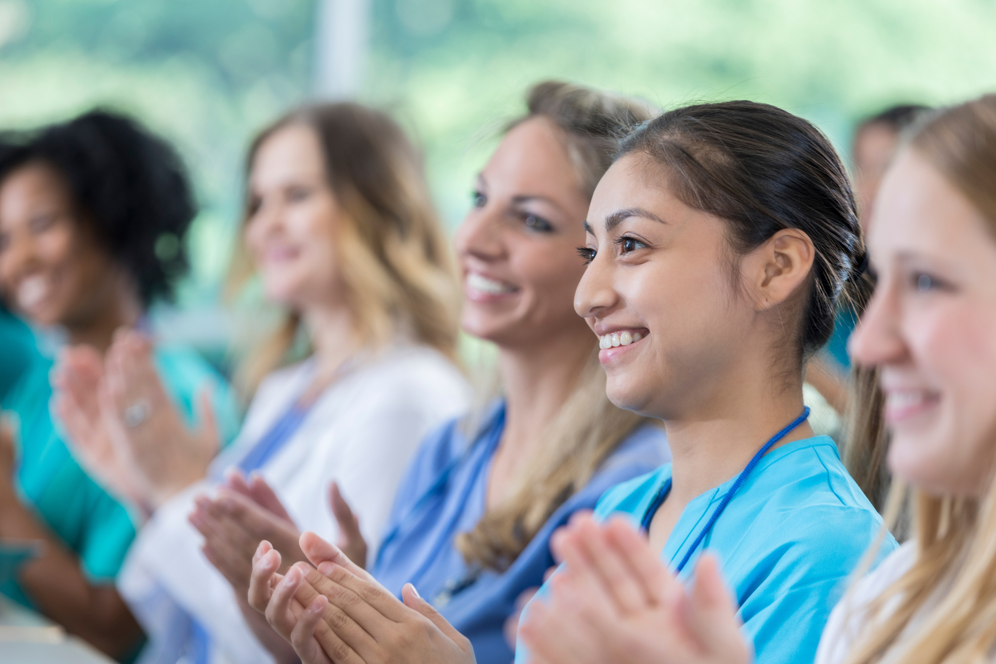 Diverse healthcare professionals applaud after seminar